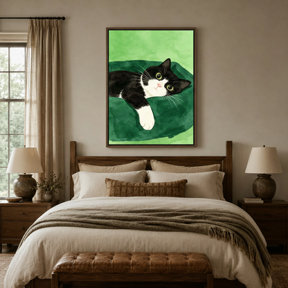 Tuxedo cat lounging canvas print styled above bed in warm bedroom interior setting