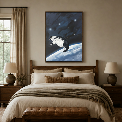 Cosmic space cat canvas in walnut floater frame above a linen bed in a warm neutral bedroom