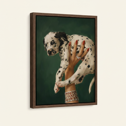Dark walnut framed canvas of a woman's red-nailed hand lifting a Dalmatian puppy, angled view