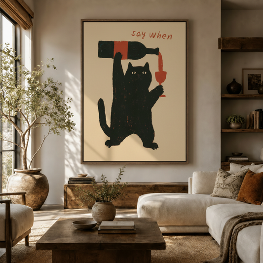 Large say when black cat canvas print hung above a white sofa in a bright modern living room